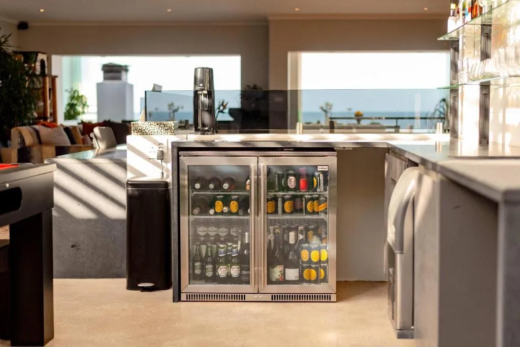 Built-in bar nook with a glass-door beverage fridge beside the kitchen counter