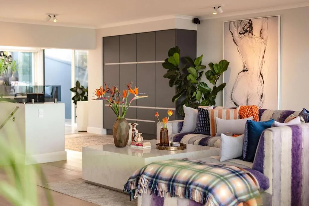 Living room with a purple striped sofa, marble coffee table and large charcoal artwork
