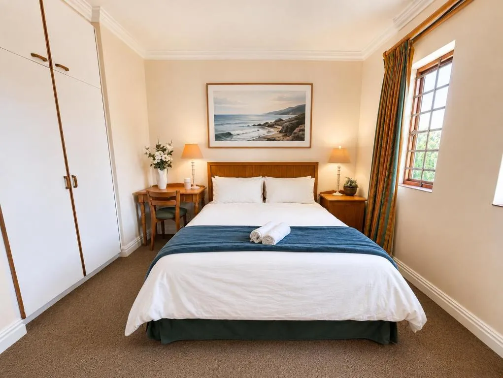 Bedroom with a double bed, fitted wardrobe and a window onto the garden