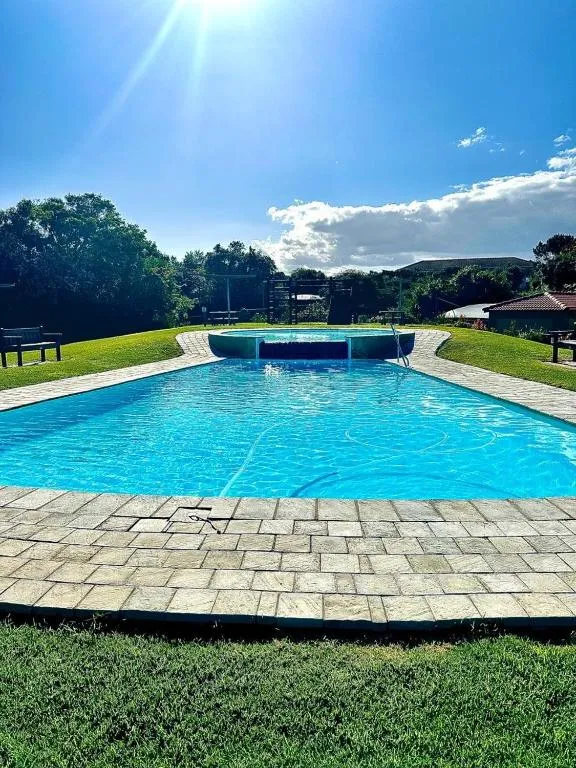 Communal estate swimming pool with a raised spa feature, lawns, and benches shared by residents