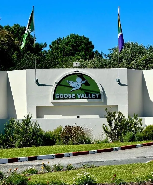 Goose Valley estate entrance sign with the estate crest between two flagpoles at the driveway