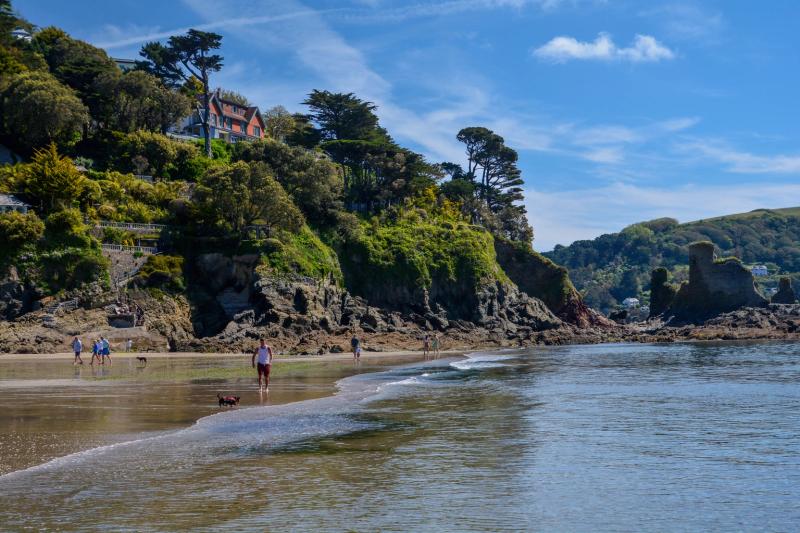 North Sands, Salcombe, at low water, with wooded cliffs and houses above the beach and the ruins of Fort Charles on the headland