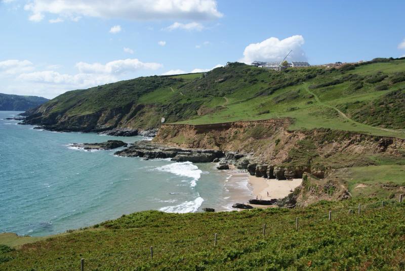 Gara Rock beach and the cliffs of the East Portlemouth shore, with buildings on the headland above the cove